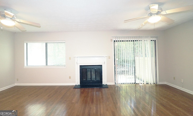 2929 Torreya Way SE, Marietta, GA 30067 - unfurnished living room featuring ceiling fan, hardwood / wood-style flooring, a glass covered fireplace, and baseboards