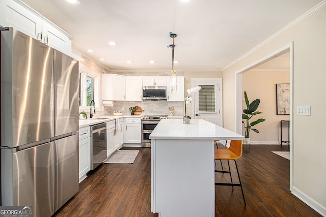 9640 Cedar Grove Rd, Fairburn, GA 30213 - kitchen featuring appliances with stainless steel finishes, a sink, dark wood finished floors, a kitchen bar, and crown molding