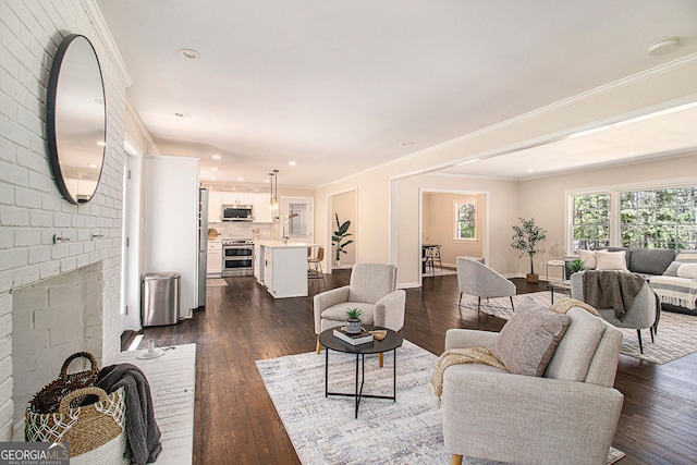 9640 Cedar Grove Rd, Fairburn, GA 30213 - living room featuring dark wood-style flooring, baseboards, recessed lighting, crown molding, and a brick fireplace