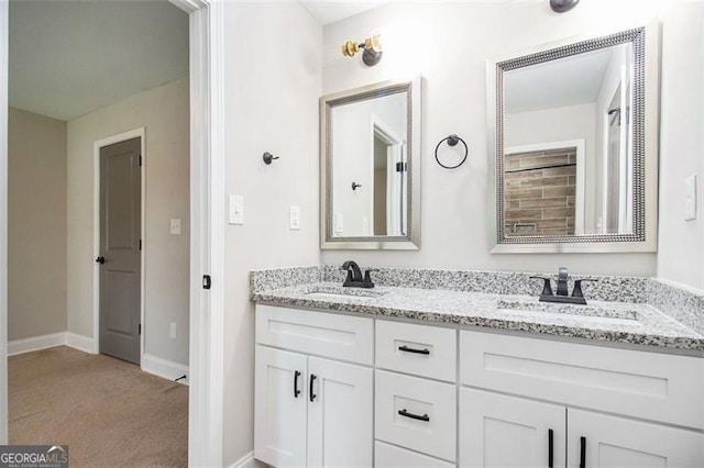 bathroom featuring baseboards, double vanity, and a sink
