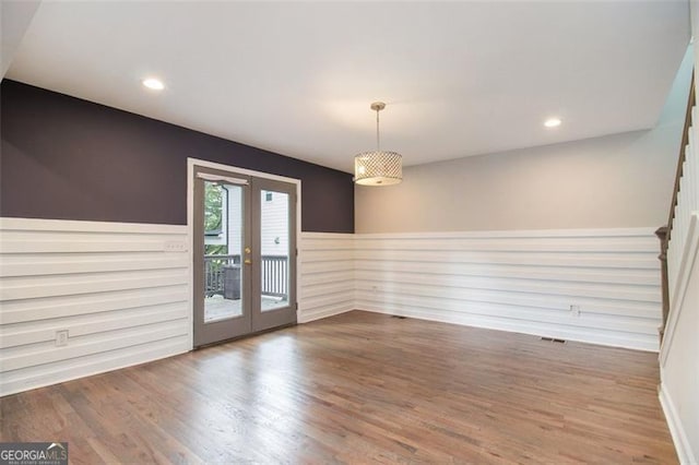 spare room with a wainscoted wall, stairs, wood finished floors, recessed lighting, and french doors