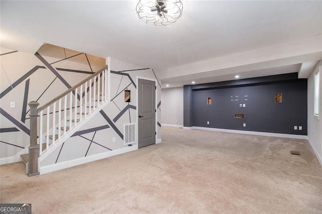 finished basement featuring carpet flooring, stairway, and visible vents