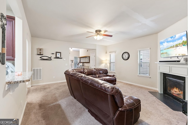 6018 Cloverfield Way, Braselton, GA 30517 - living room with light colored carpet, ceiling fan, a glass covered fireplace, and baseboards