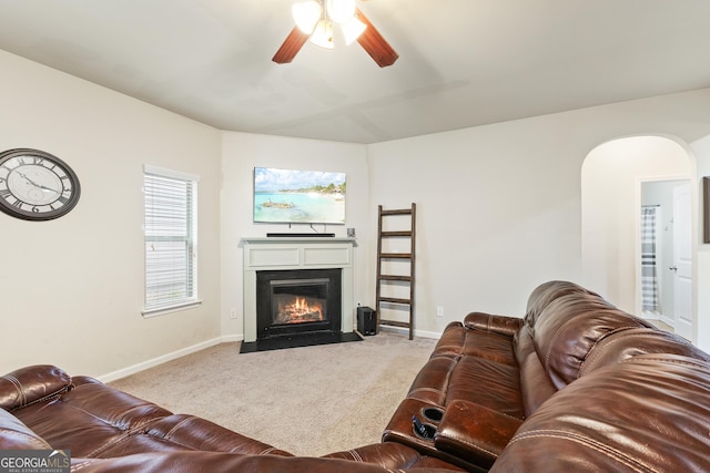 6018 Cloverfield Way, Braselton, GA 30517 - carpeted living area featuring a fireplace with flush hearth, ceiling fan, arched walkways, and baseboards