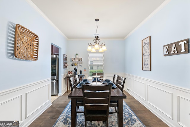 6018 Cloverfield Way, Braselton, GA 30517 - dining space with ornamental molding, a chandelier, dark wood finished floors, wainscoting, and a decorative wall