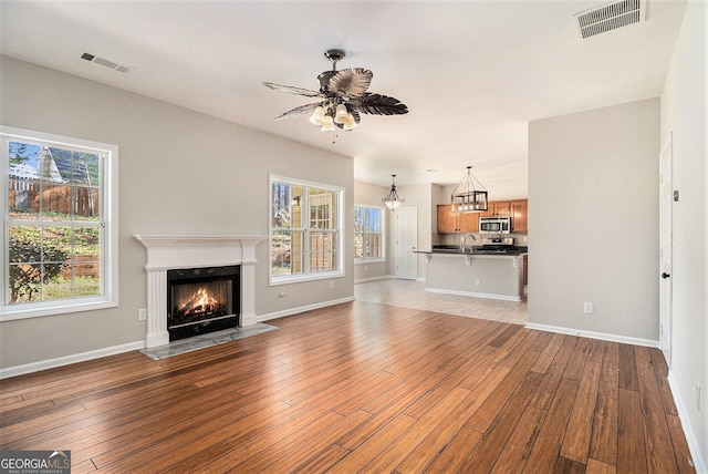 3707 Mcguire St NW, Kennesaw, GA 30144 - unfurnished living room with light wood-type flooring, ceiling fan, a premium fireplace, and baseboards