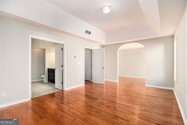 3707 Mcguire St NW, Kennesaw, GA 30144 - empty room with hardwood / wood-style floors, arched walkways, baseboards, and a raised ceiling