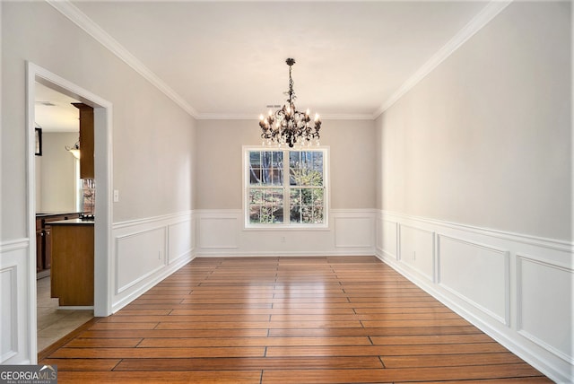 3707 Mcguire St NW, Kennesaw, GA 30144 - unfurnished dining area featuring plenty of natural light, a chandelier, hardwood / wood-style floors, a wainscoted wall, and ornamental molding