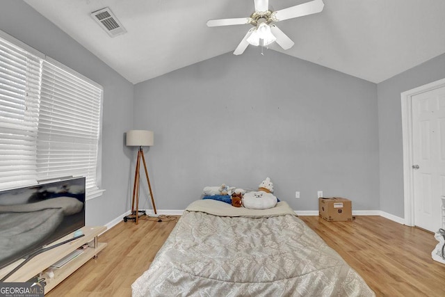 bedroom with wood finished floors, lofted ceiling, baseboards, visible vents, and ceiling fan
