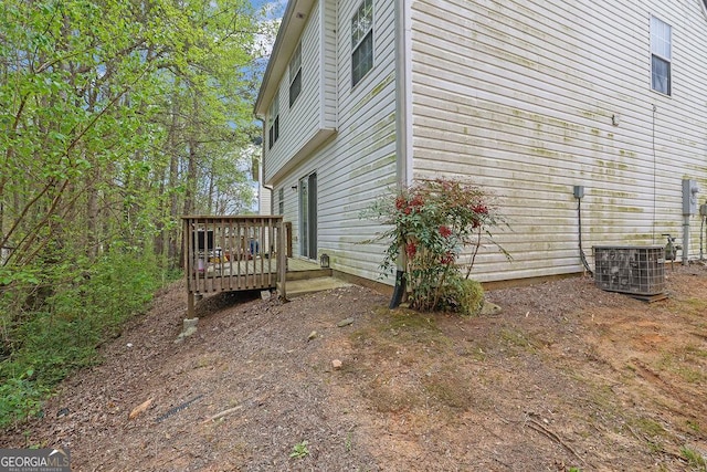 view of side of home featuring a deck and central AC