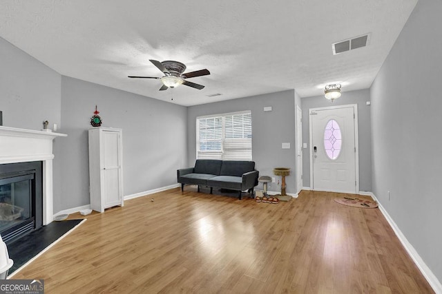 entryway with a wealth of natural light, visible vents, light wood-type flooring, and a ceiling fan