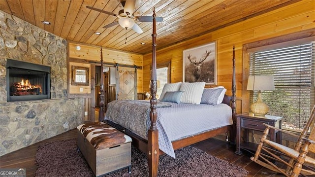 68 Shalom Vw, Blue Ridge, GA 30513 - bedroom with wooden ceiling, wood walls, hardwood / wood-style floors, a barn door, and a stone fireplace