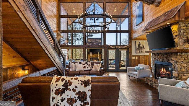 68 Shalom Vw, Blue Ridge, GA 30513 - living area with wood walls, a stone fireplace, a towering ceiling, wood-type flooring, and a chandelier
