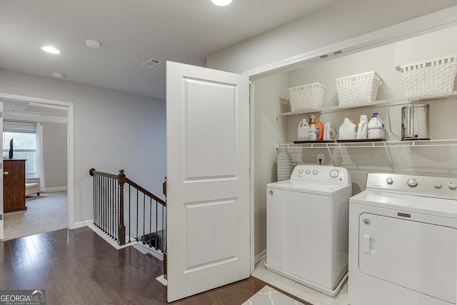 clothes washing area with washing machine and dryer, wood finished floors, baseboards, and recessed lighting