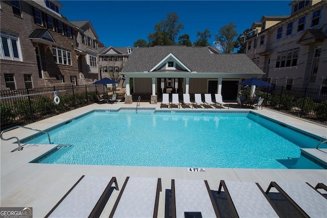 community pool featuring fence and a patio area