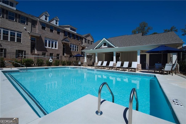 community pool featuring fence and a patio area