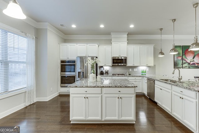 kitchen featuring stainless steel appliances, a sink, decorative backsplash, plenty of natural light, and crown molding