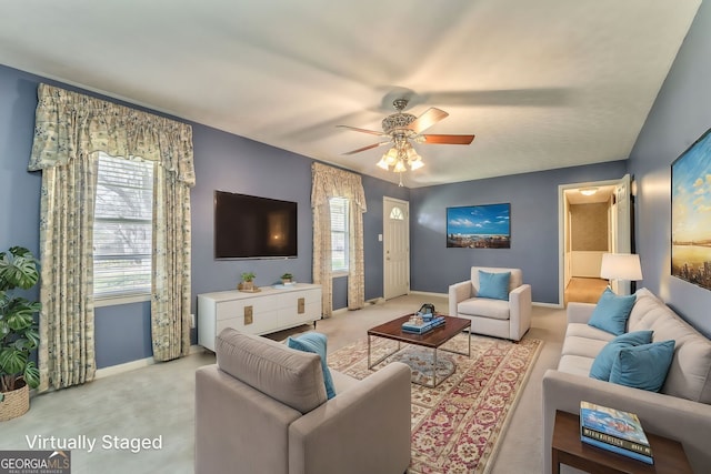 living area with carpet flooring, a ceiling fan, and baseboards