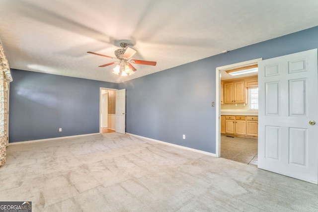 unfurnished bedroom with a ceiling fan, baseboards, and light colored carpet