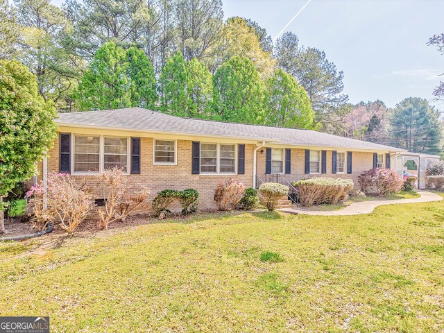 ranch-style home with a front lawn and brick siding