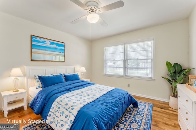 bedroom featuring light wood finished floors, baseboards, and ceiling fan