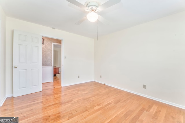 empty room featuring baseboards, light wood-style floors, and ceiling fan