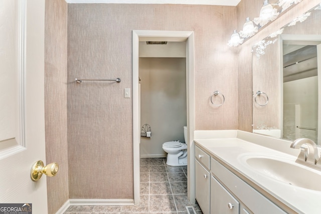 bathroom featuring visible vents, baseboards, toilet, tile patterned floors, and vanity