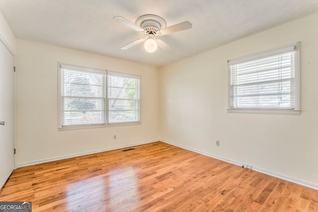 empty room featuring baseboards, ceiling fan, visible vents, and light wood finished floors