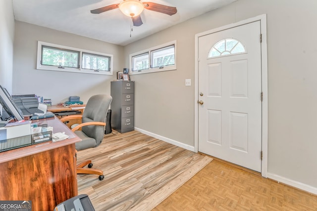office featuring baseboards, a ceiling fan, and parquet flooring
