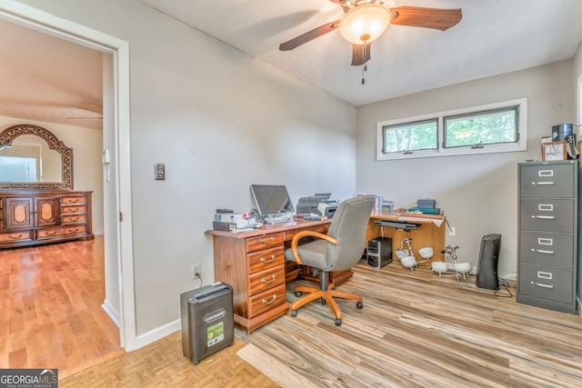 home office with baseboards, ceiling fan, and light wood-style floors