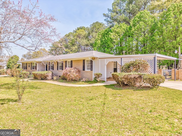 ranch-style home with driveway, a front yard, an attached carport, fence, and brick siding