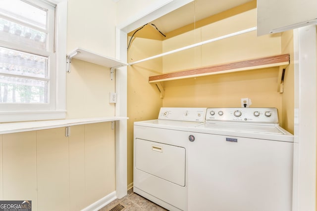 clothes washing area with washer and clothes dryer and laundry area