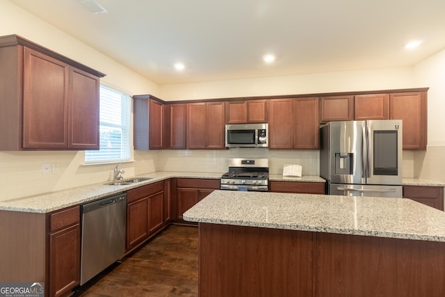 1800 Pearson St, Loganville, GA 30052 - kitchen featuring dark wood-type flooring, backsplash, a sink, light stone counters, and appliances with stainless steel finishes