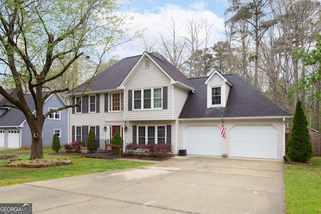 colonial inspired home featuring a garage, driveway, a shingled roof, and a front lawn
