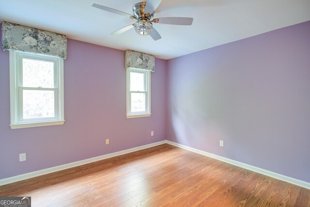 unfurnished room with light wood-type flooring, baseboards, and ceiling fan