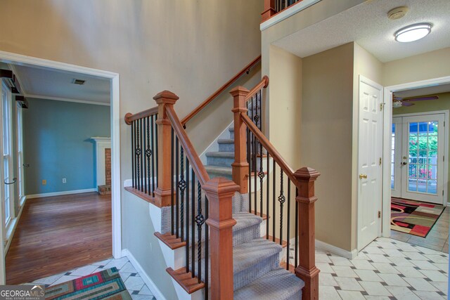 staircase featuring baseboards, a ceiling fan, and visible vents
