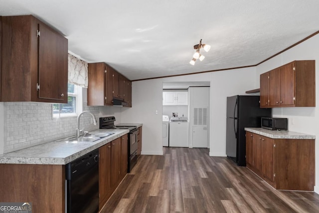 138 Forest Hill Dr, Eatonton, GA 31024 - kitchen featuring washing machine and clothes dryer, ornamental molding, under cabinet range hood, a sink, and black appliances