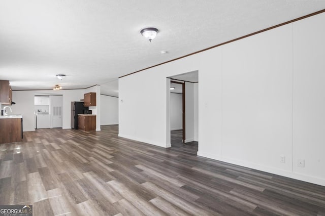 138 Forest Hill Dr, Eatonton, GA 31024 - unfurnished living room with a textured ceiling, dark wood-style floors, a sink, and ornamental molding