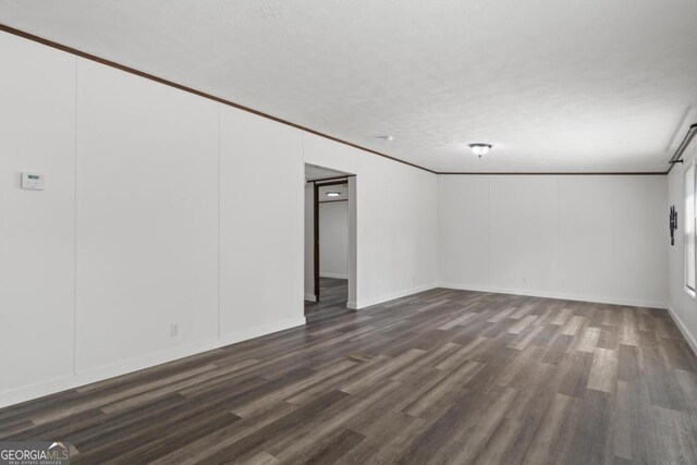 138 Forest Hill Dr, Eatonton, GA 31024 - unfurnished room with dark wood-type flooring, a textured ceiling, and ornamental molding