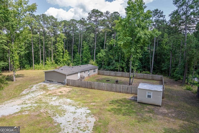 138 Forest Hill Dr, Eatonton, GA 31024 - view of yard with an outbuilding, fence, a forest view, driveway, and a storage shed