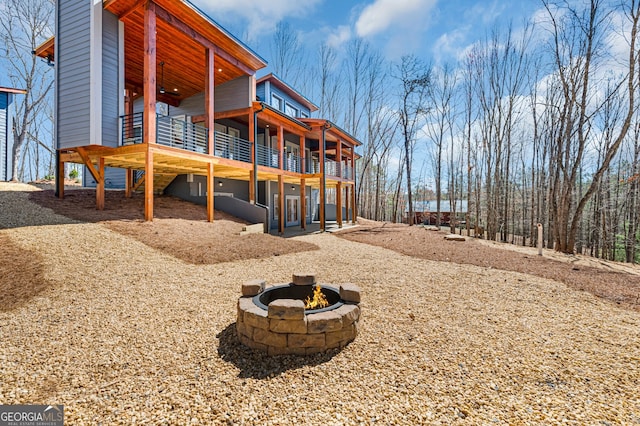 exterior space featuring a fire pit, a wooden deck, and ceiling fan