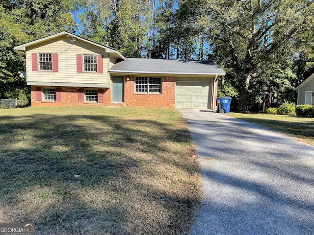 tri-level home with brick siding, driveway, an attached garage, and a front lawn