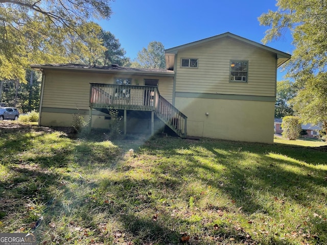 rear view of house with a wooden deck, stairway, and a yard