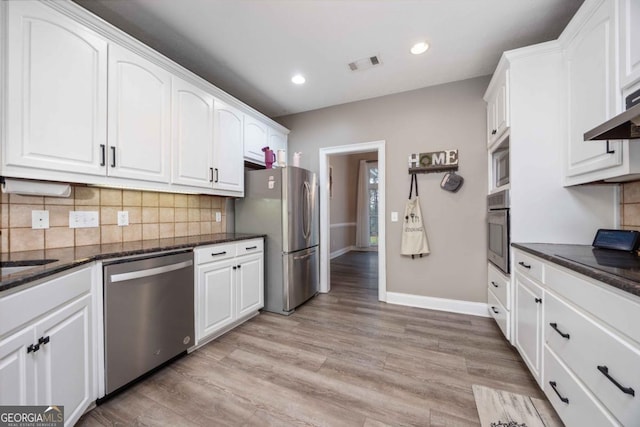 kitchen featuring stainless steel appliances, visible vents, white cabinetry, and backsplash