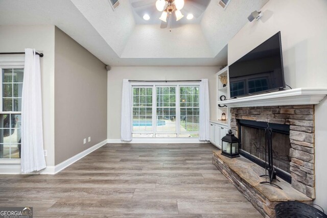 living room with light wood-style flooring, a textured ceiling, baseboards, and a ceiling fan