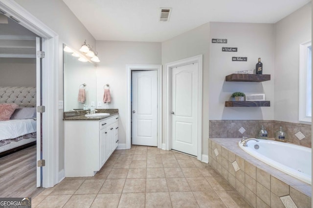 bathroom with vanity, tile patterned flooring, connected bathroom, a bath, and visible vents