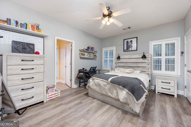 bedroom featuring light wood-type flooring, baseboards, a ceiling fan, and visible vents