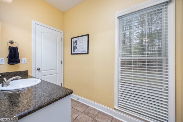 bathroom with tile patterned floors, vanity, and baseboards