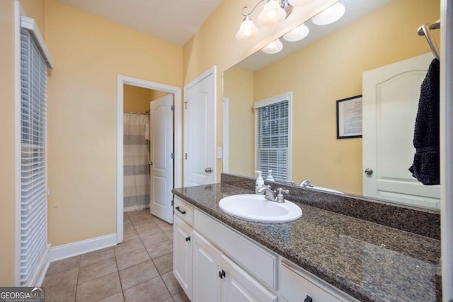 full bathroom with tile patterned floors, vanity, and baseboards