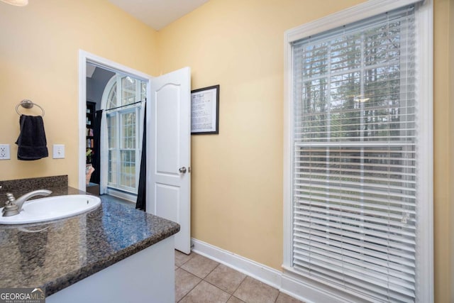 bathroom with tile patterned floors, vanity, and baseboards